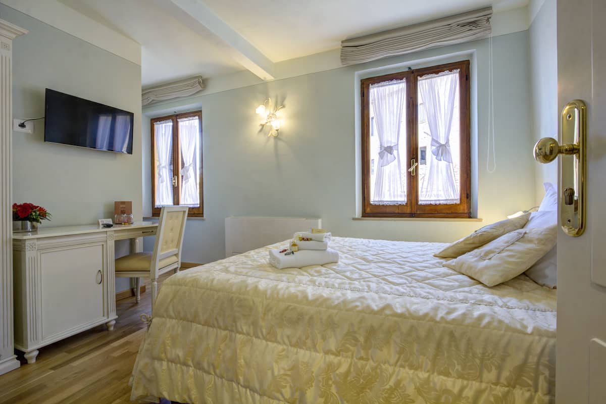 Ein Schlafzimmer mit Bett, Schreibtisch, Stuhl und Fernseher.