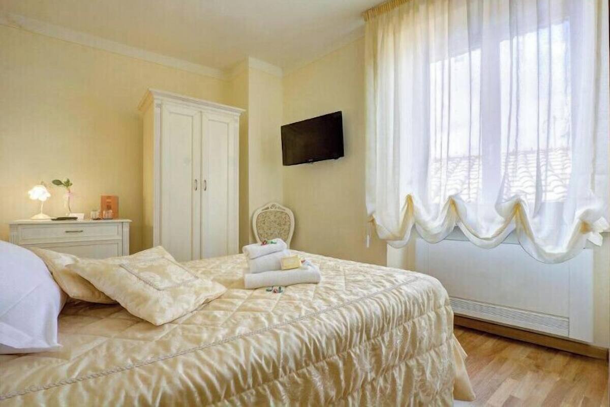 Ein Schlafzimmer mit einem Bett, einem Nachttisch, einem Fernseher und einem Kleiderschrank.