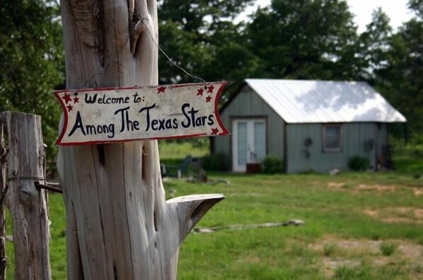 A wooden post with a sign that reads "Welcome to Among The Texas Stars." - The B&B's of Monarc Ranch (Fredericksburg)