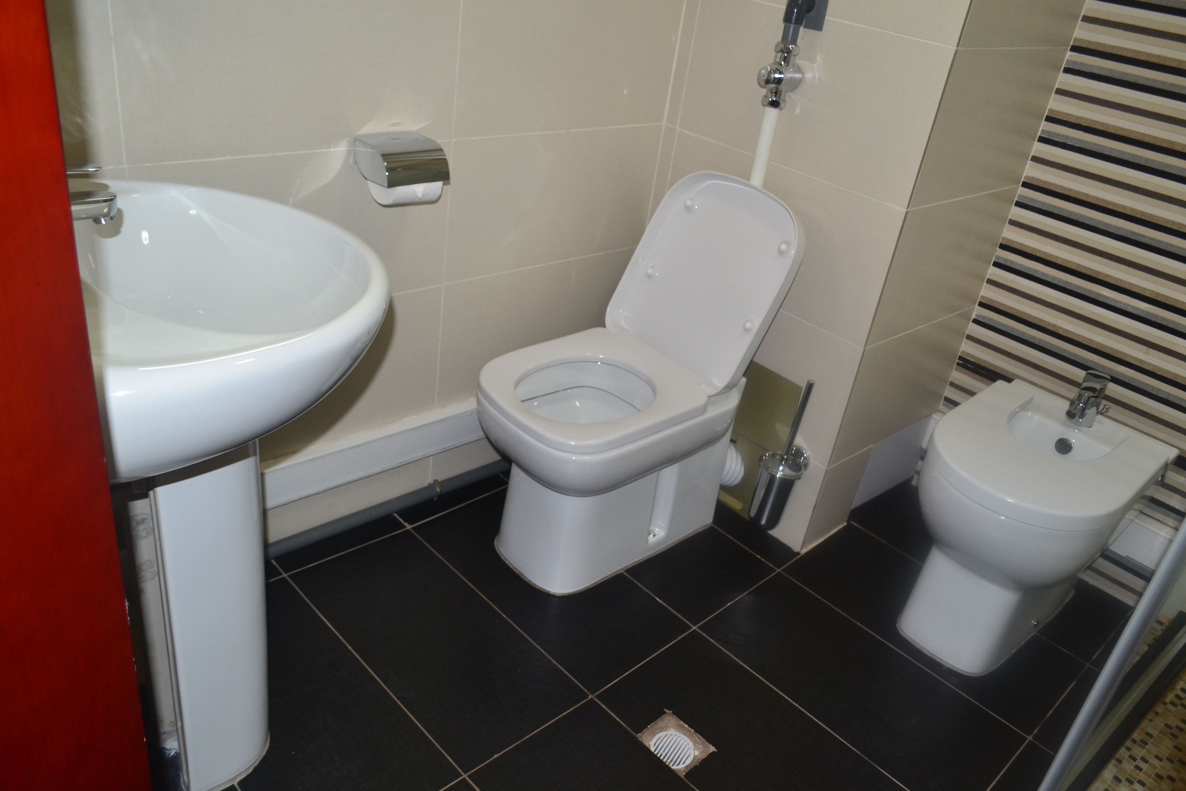 Un baño con inodoro, bidé y lavamanos.