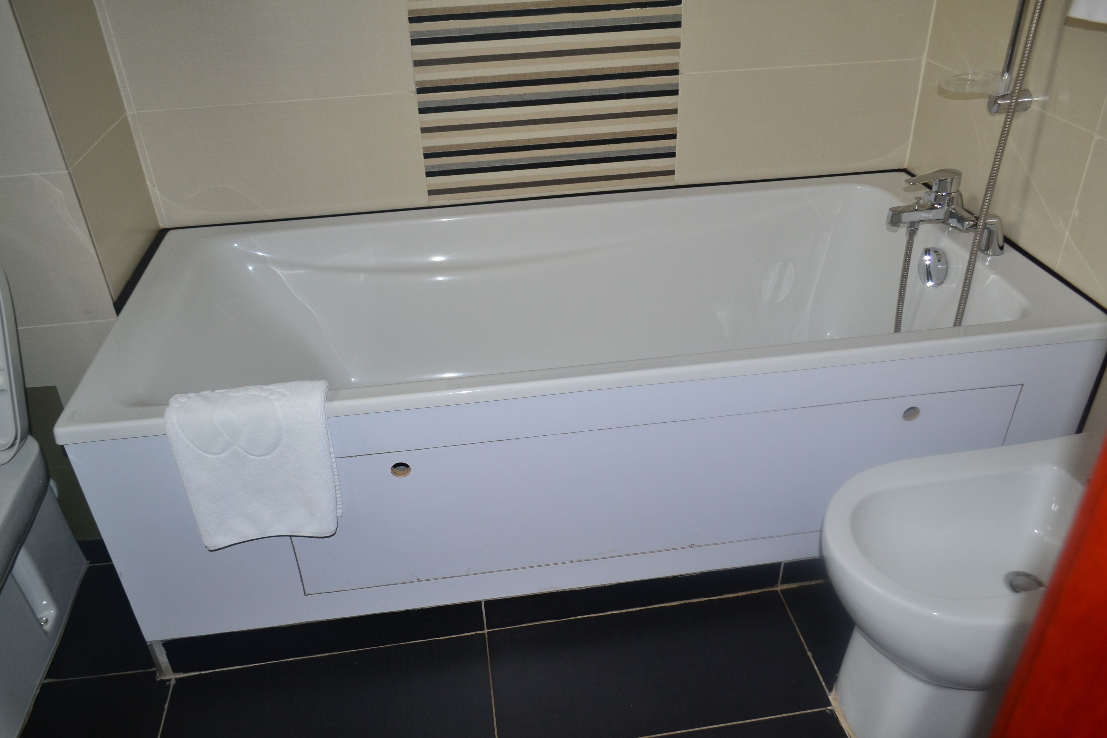 Une salle de bain standard équipée d’une baignoire, de toilettes et d’un bidet.