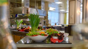 A kitchen counter with various bowls of fresh vegetables and herbs. - Blue Pearl Hotel (Sunny Beach)