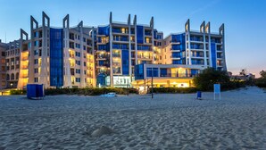 A multi-story hotel with a modern architectural design, featuring balconies and large windows. - Blue Pearl Hotel (Sunny Beach)