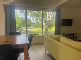 Une pièce comprenant une table à manger, des chaises, un canapé et un téléviseur.