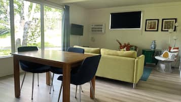 Cabaña estándar, 1 cama Queen size | Área de sala de estar | Televisión de 32 pulgadas con canales vía satélite