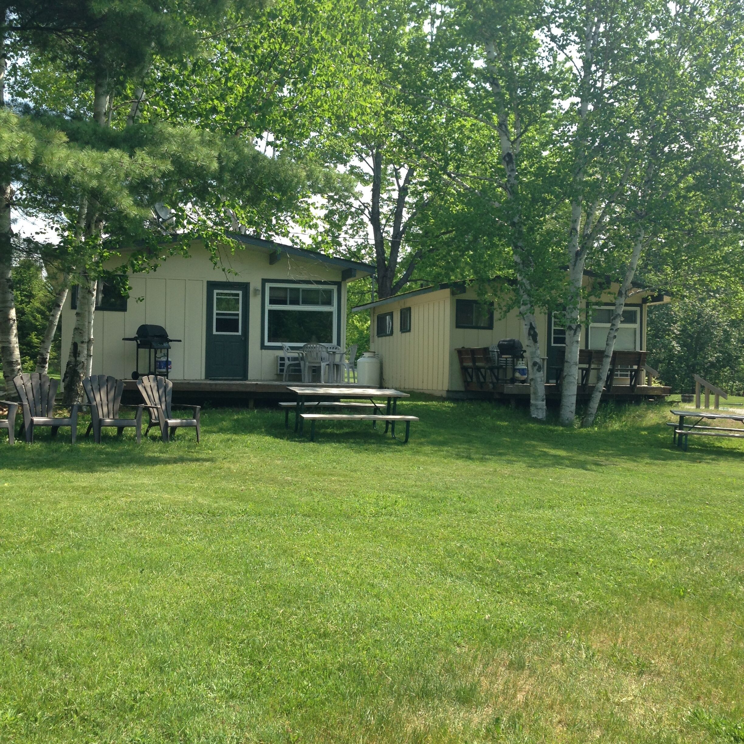 A small, single-story house with a front porch and a picnic table.