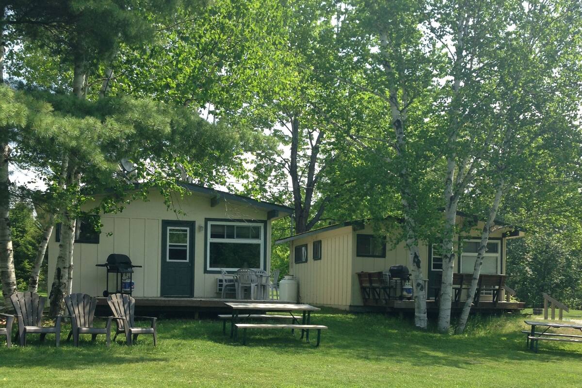 A small, single-story house with a front porch and a picnic table.