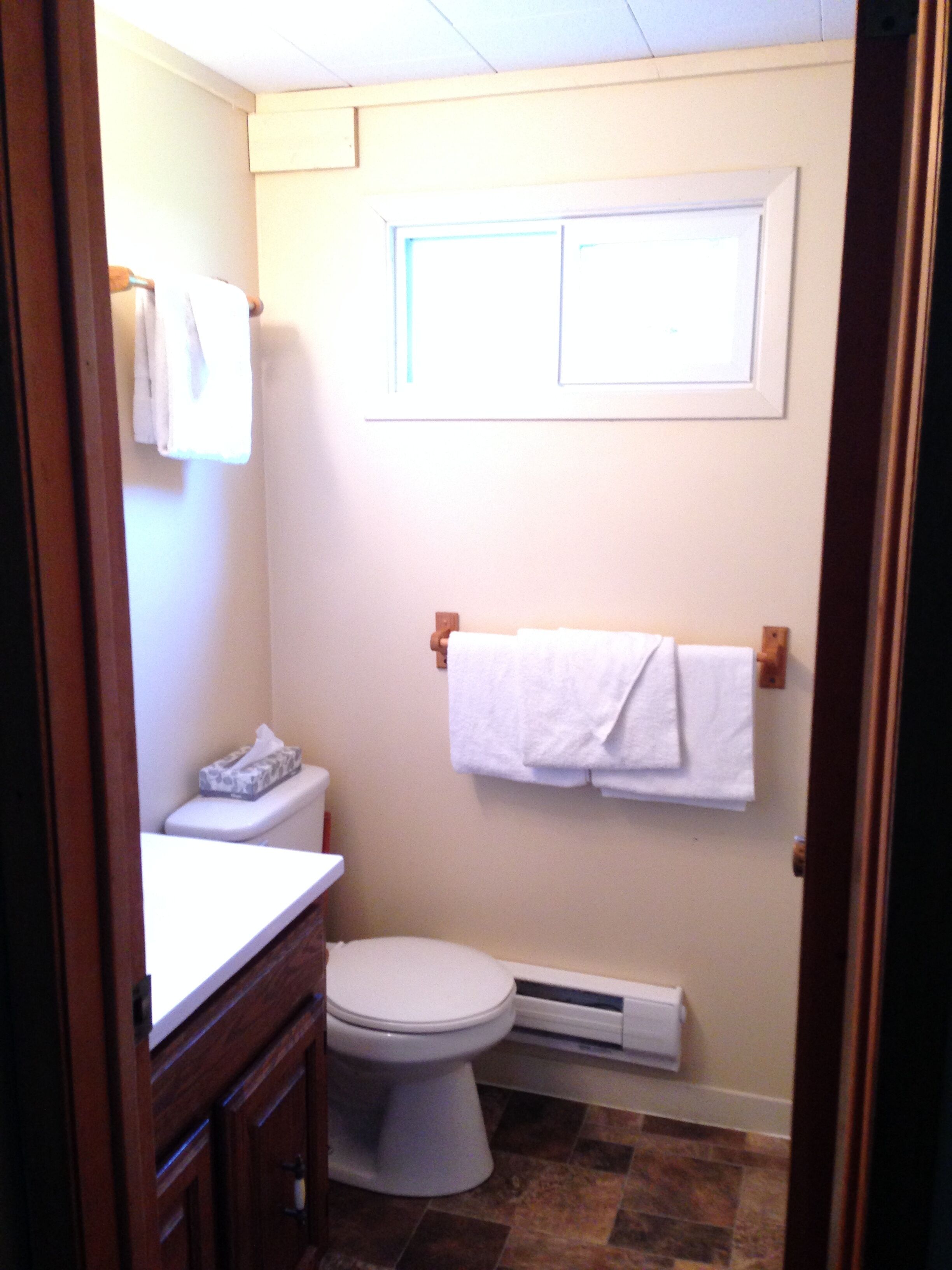 Ein kleines Badezimmer mit Toilette, Waschbecken und Handtuchhalter.