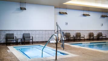 Una piscina interior con dos carriles, sillas a lo largo de las paredes y suelo de baldosas.