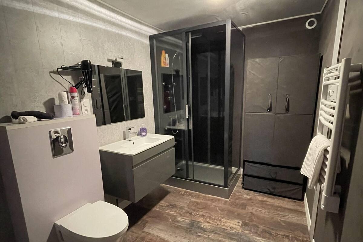A compact bathroom with a toilet, sink, and shower.