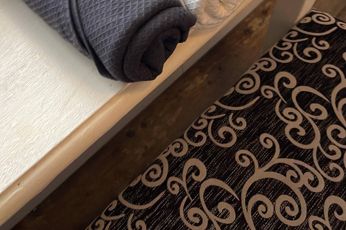 A set of neatly folded towels in various colors on a wooden shelf.