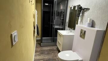 Un baño moderno con inodoro, lavabo y zona de ducha.
