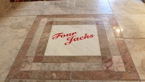 A tiled floor with a square tile in the center displaying the text "Four Jacks". - Four Jacks Hotel and Casino (Jackpot)