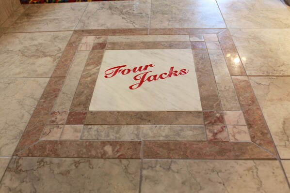 A tiled floor with a square tile in the center displaying the text "Four Jacks". - Four Jacks Hotel and Casino (Jackpot)