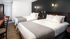 Een hotelkamer met twee bedden, een houten bureau en een stoel.