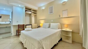 A hotel room with a bed, bedside tables, a desk, and a wardrobe. - Hotel Recanto dos Pássaros (São Sebastião)