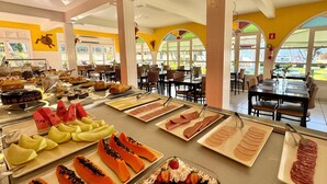 A buffet with various fruits, pastries, and meats. - Hotel Recanto dos Pássaros (São Sebastião)
