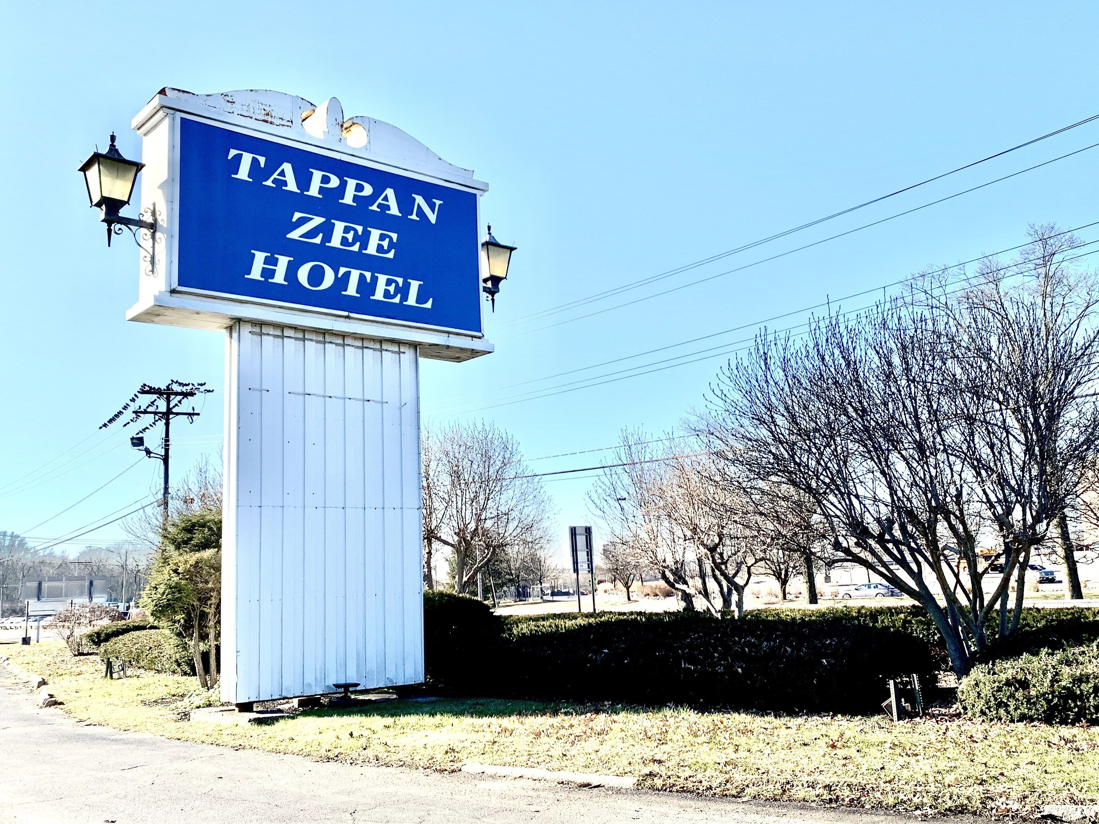 A Tappan Zee Hotel sign with a blue background and white lettering.