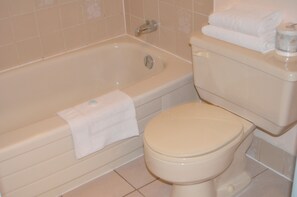 Bathroom features a bathtub, toilet, and towel.