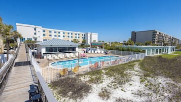 Un hotel con piscina, zona de estar al aire libre y paseo marítimo.