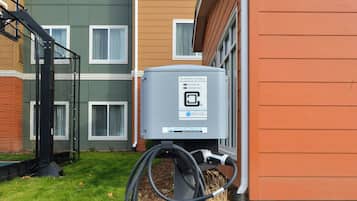 Una estación de carga para vehículos eléctricos frente a un edificio residencial.