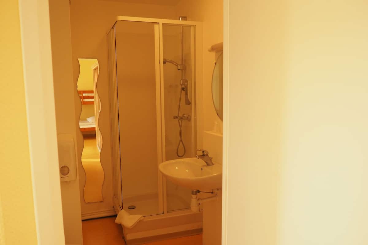 A bathroom with a shower, toilet, and sink.