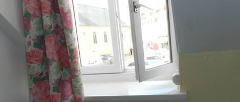A room with a window, a radiator, and a chair.