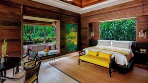 A modern bedroom with a large bed, a sofa, and a dining table.