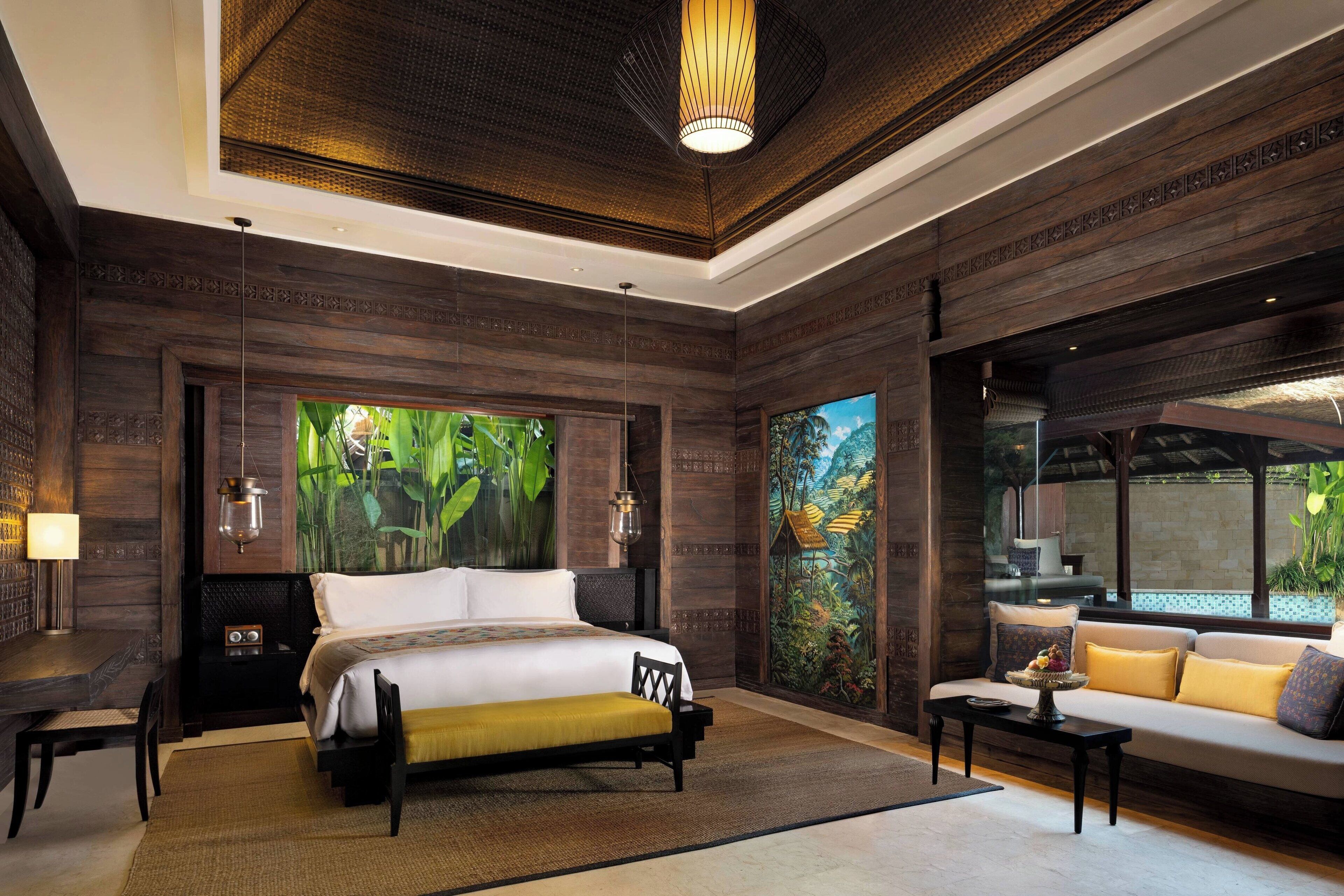 A spacious bedroom with a large bed, a sofa, and a dining table.