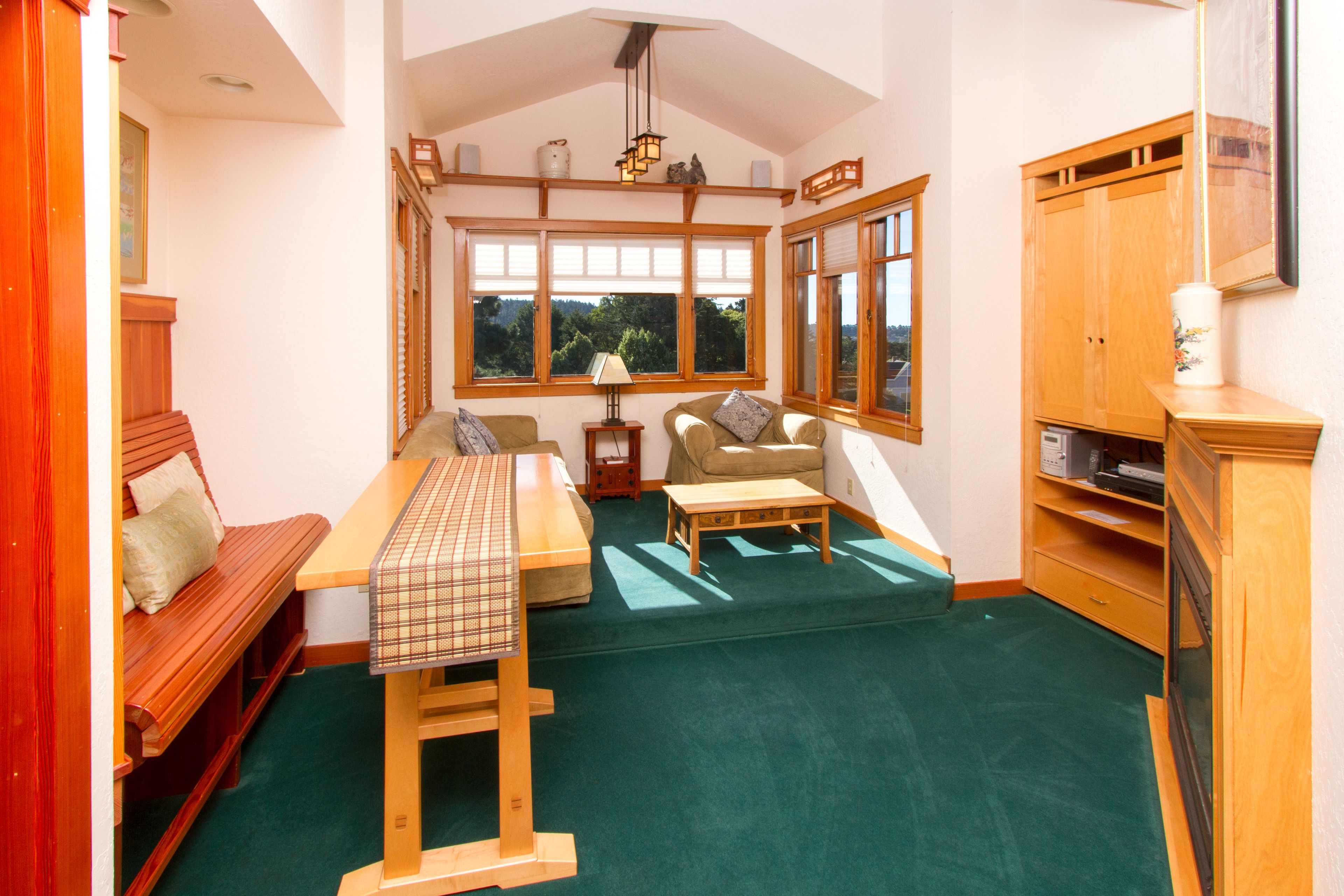 A cozy room with a wooden bench, a small table, a sofa, and a cabinet.