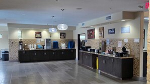 A spacious, well-lit kitchen area with modern appliances, a central island, and a tiled backsplash. - Karnes City Lodge  (Karnes City)