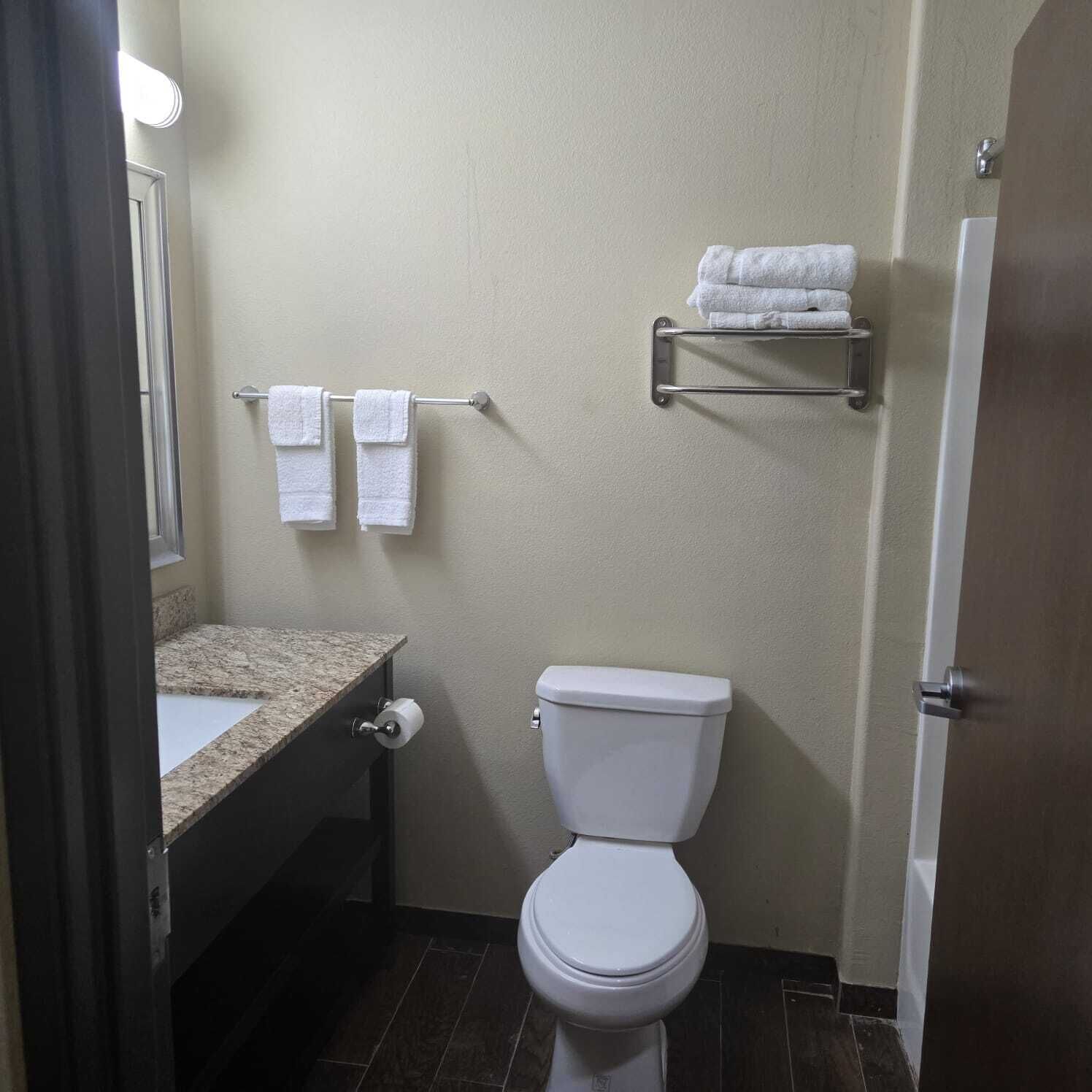 A small bathroom with a toilet, sink, and towel rack.
