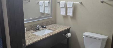 A bathroom with a sink, mirror, towel rack, and toilet.
