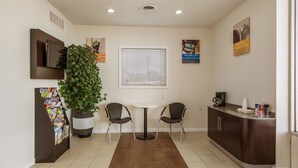 A small, modern kitchen with a dining area, a coffee machine, and a potted plant. - Motel 6 Van Buren, AR (Van Buren)