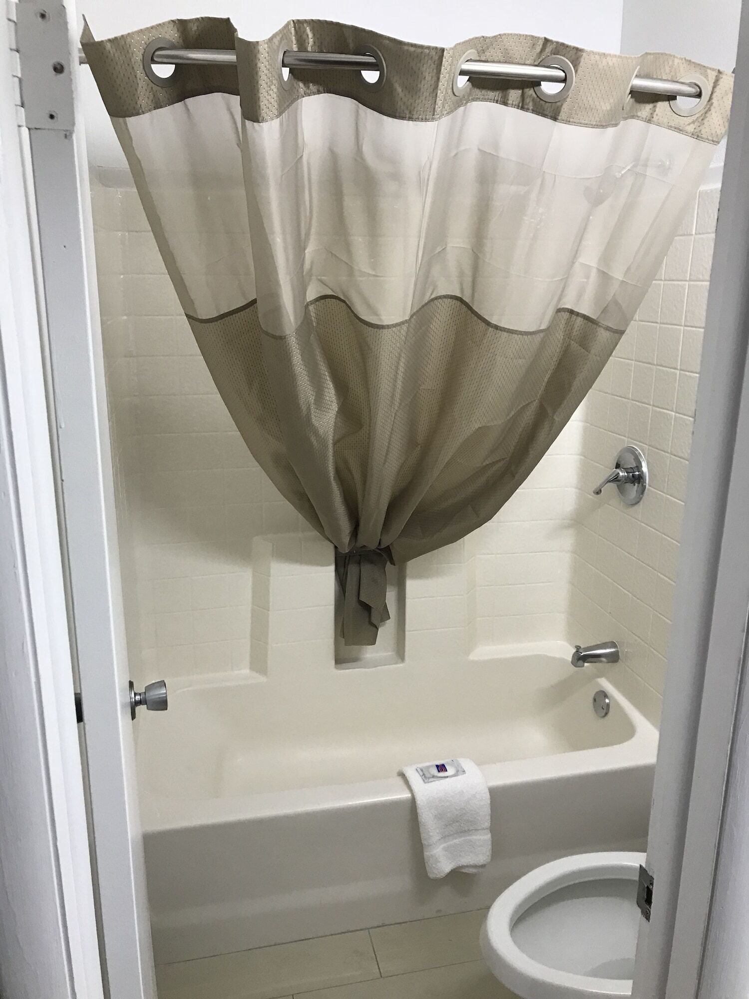 Un baño con bañera, inodoro y cortina de ducha.