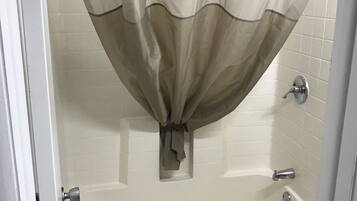 Un baño con bañera, inodoro y cortina de ducha.