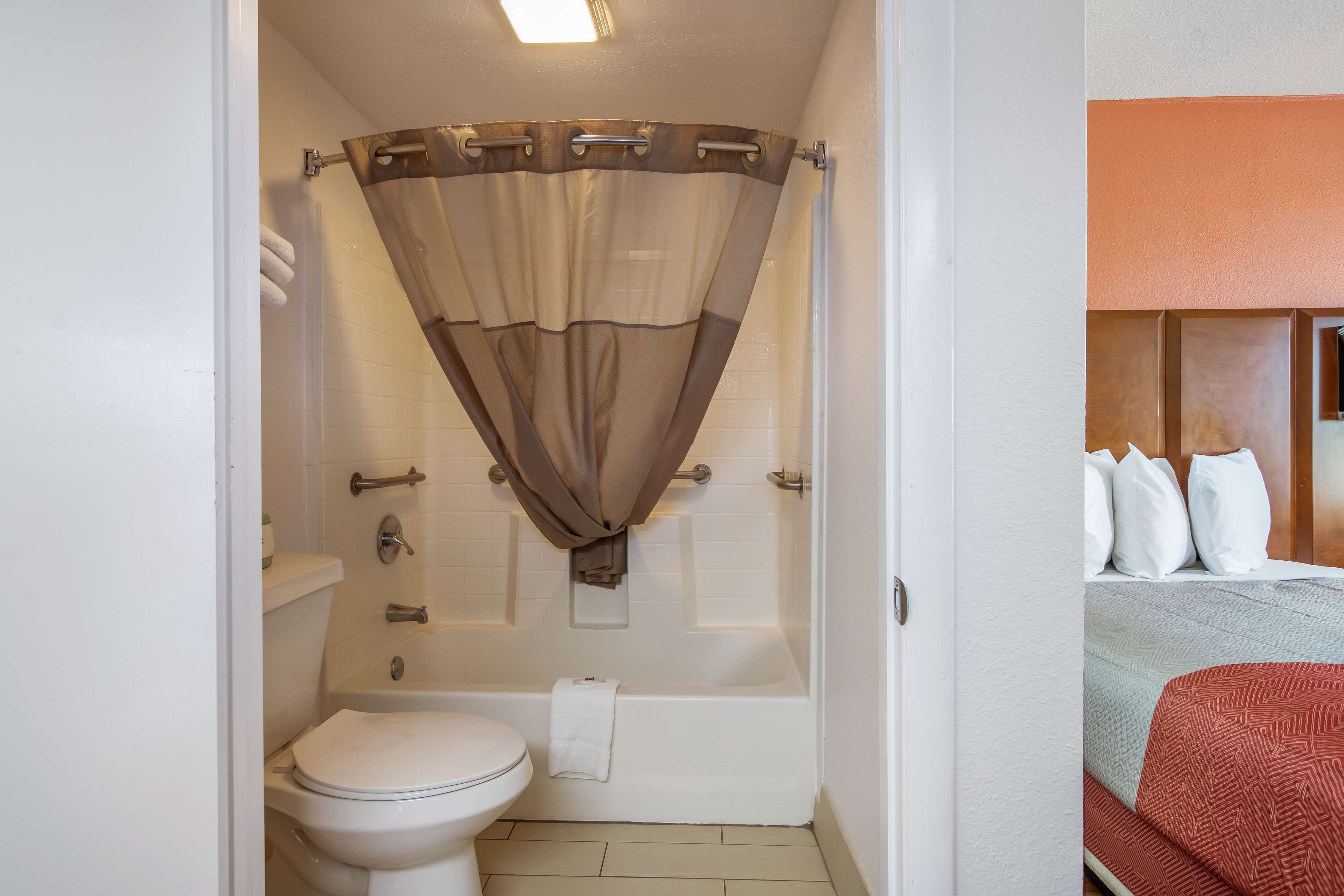 Ein Badezimmer mit Badewanne, Toilette und Duschvorhang.