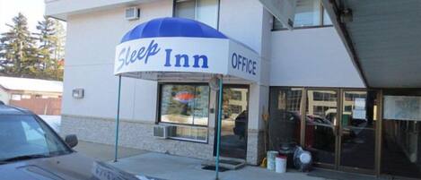 A Sleep Inn office building with a blue awning and a visible entrance.