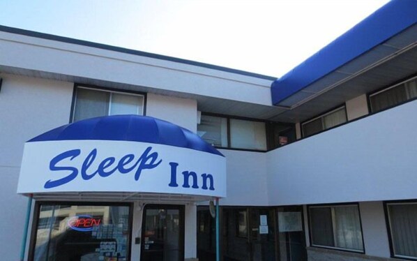 A Sleep Inn building with a prominent blue awning and a clear sign.