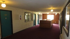 A hallway with a reception desk, a door labeled "200", and a window with blinds.