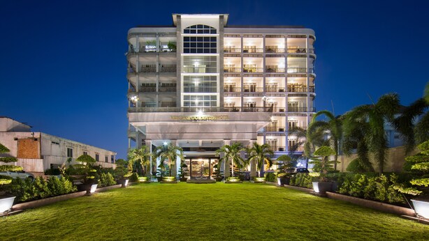 A multi-story hotel with a well-maintained lawn in front, large windows, and a sign reading "VENTIAN GOLDEN SUN HOTEL". - Vientiane Golden Sun Hotel & Spa (Vientiane)