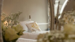 A bedroom with a bed, a nightstand, and a mirror. - Poole Farm (Launceston)