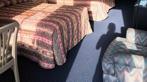 A hotel room with two beds, a chair, a desk, a lamp, a mirror, and a window. - Claridge Inn (Waynesboro)