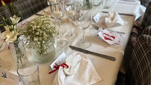 A long dining table set with glassware, cutlery, and floral centerpieces. - The Lower Bell (Aylesford)