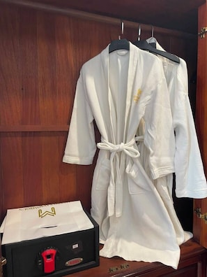 A wooden wardrobe with two white robes hanging on hangers. - Xaysomboun Hotel & Spa (Vientiane)