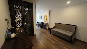 A modern living room with a sofa, a wooden coffee table, and a decorative screen.