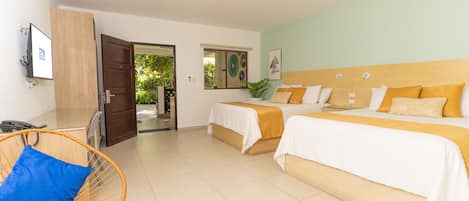 A hotel room with two beds, a wooden headboard, a blue chair, and a door leading outside.