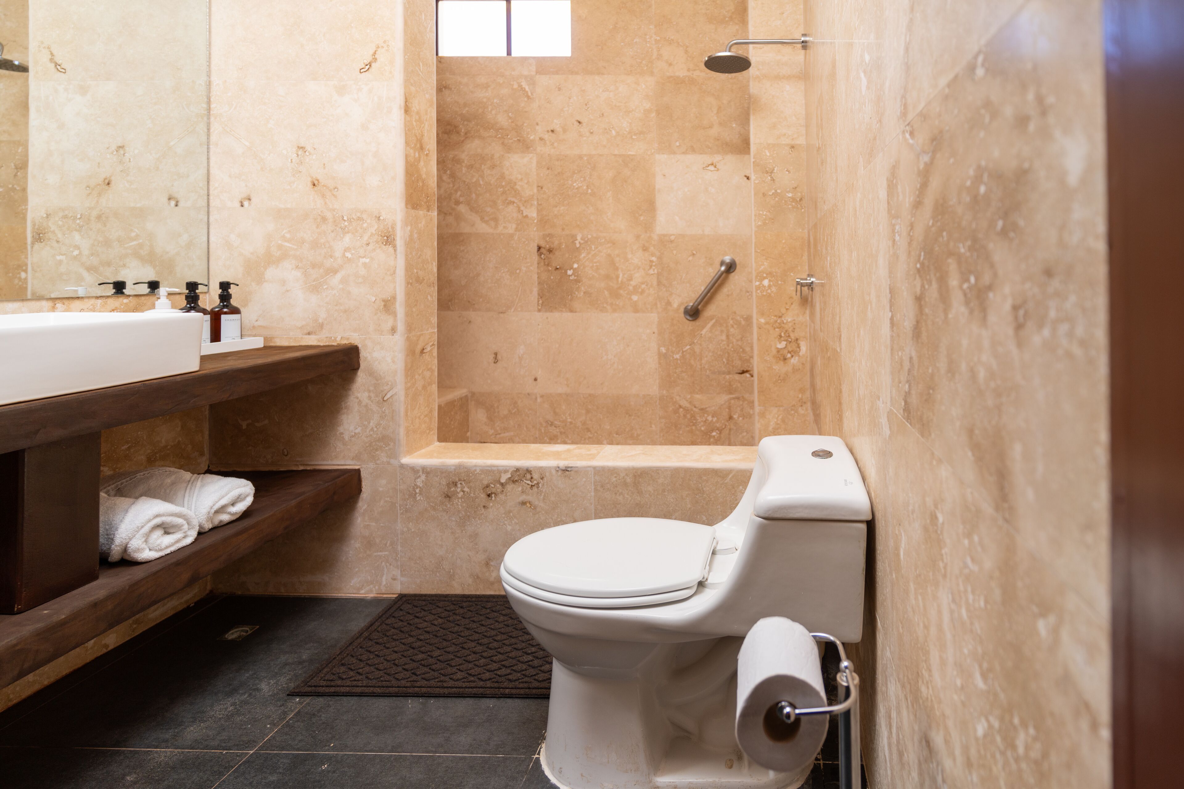 A bathroom with a toilet, a sink, and a shower area.
