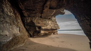 A beach with a natural rock formation.