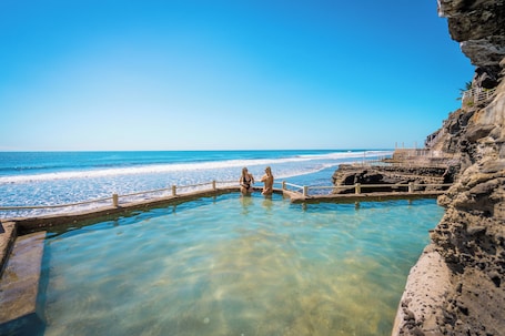4 piscinas al aire libre, una piscina infinita, sombrillas